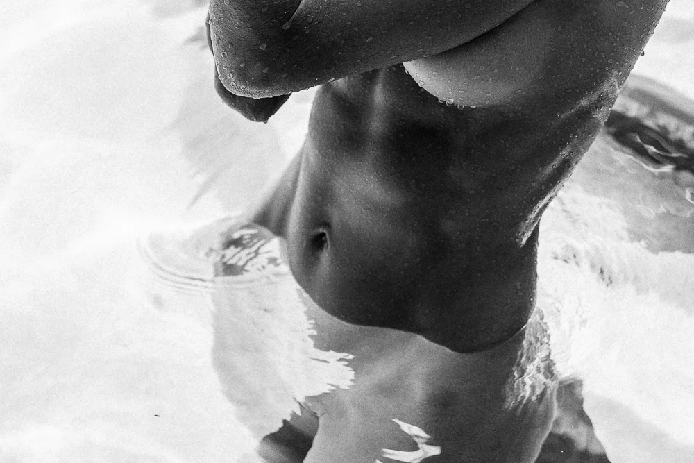 Black and white photograph of a figure in rippling water, CRZYPNDA