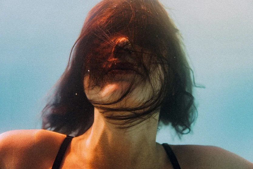 Underwater portrait with red hair suspended in blue water — CRZYPNDA
