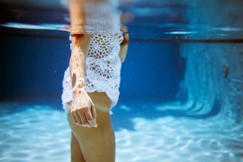 White lace swimsuit at the waterline of a pool — CRZYPNDA underwater photography
